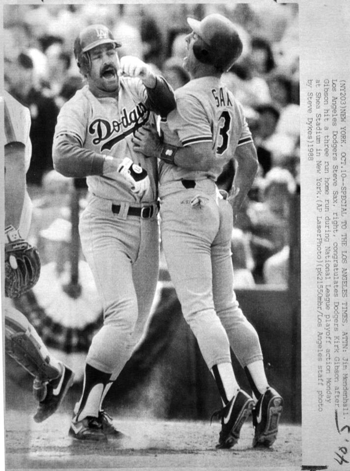 Los Angeles Dodgers Steve Sax, right, congratulates Dodgers Kirk Gibson after Gibson hit a three run home run during National League playoff action at Shea Stadium in New York October 10, 1988. Steve Dykes / Los Angeles Times.