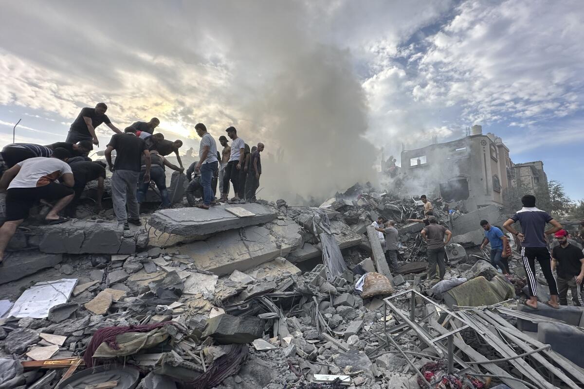 Palestinians look for survivors in the rubble of buildings at Nusseirat refugee camp.