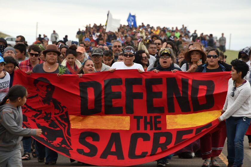 Standing Rock Sioux tribal members march to an area they contend is a burial ground that was disturbed by bulldozers clearing the way for the Dakota Access Pipeline.