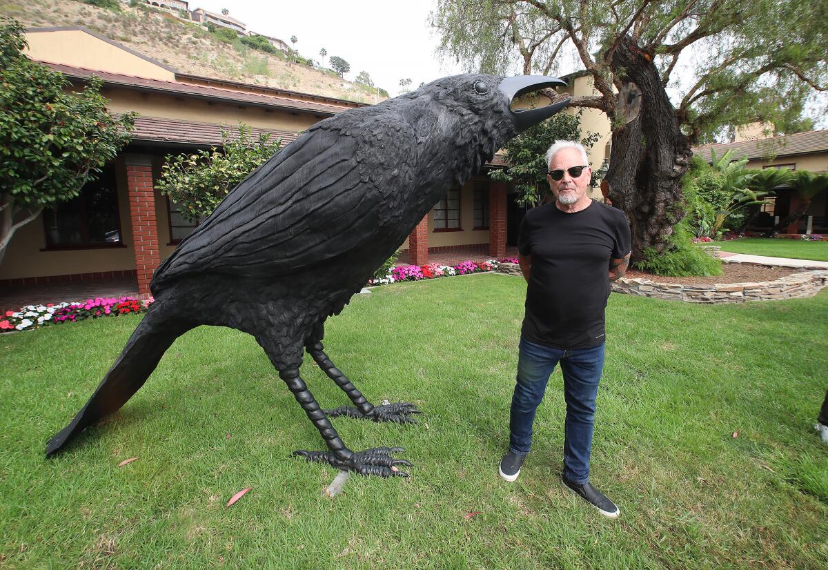 Jack Champion stands beside one of the large bronze crows from his "An Attempted Murder" art piece.