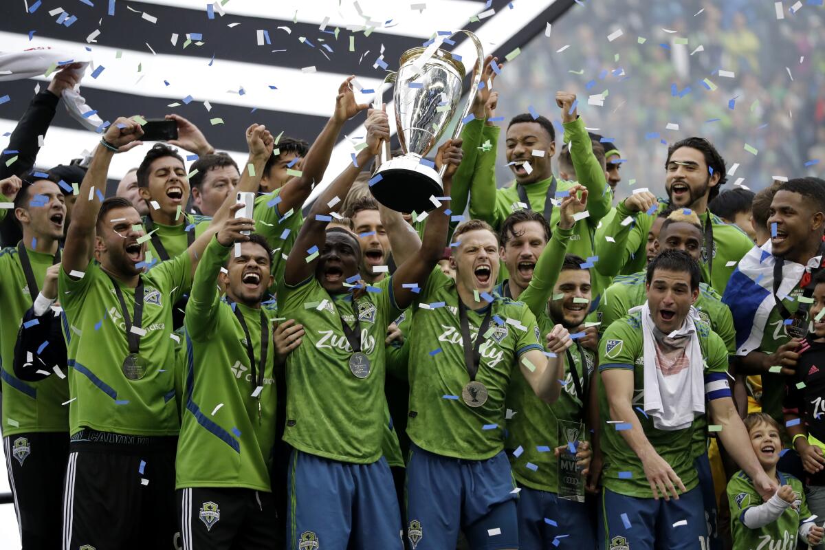 FILE - In this Sunday, Nov. 10, 2019 file photo, Seattle Sounders celebrate after the team beat the Toronto FC in the MLS Cup championship soccer match in Seattle. The Seattle Sounders are known for making the Major League Soccer postseason in each year of the club’s existence. The team has also shown the ability to correctly assess when it needs to overhaul its personnel, whether it’s bringing in an influx of fresh talent or giving younger players in the system a chance. That's the decision the Sounders made going into the 2021 season. (AP Photo/Elaine Thompson, File)