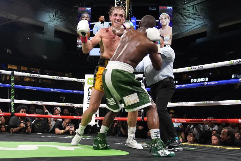 Logan Paul, left, and Floyd Mayweather, right, fight during an exhibition boxing match.