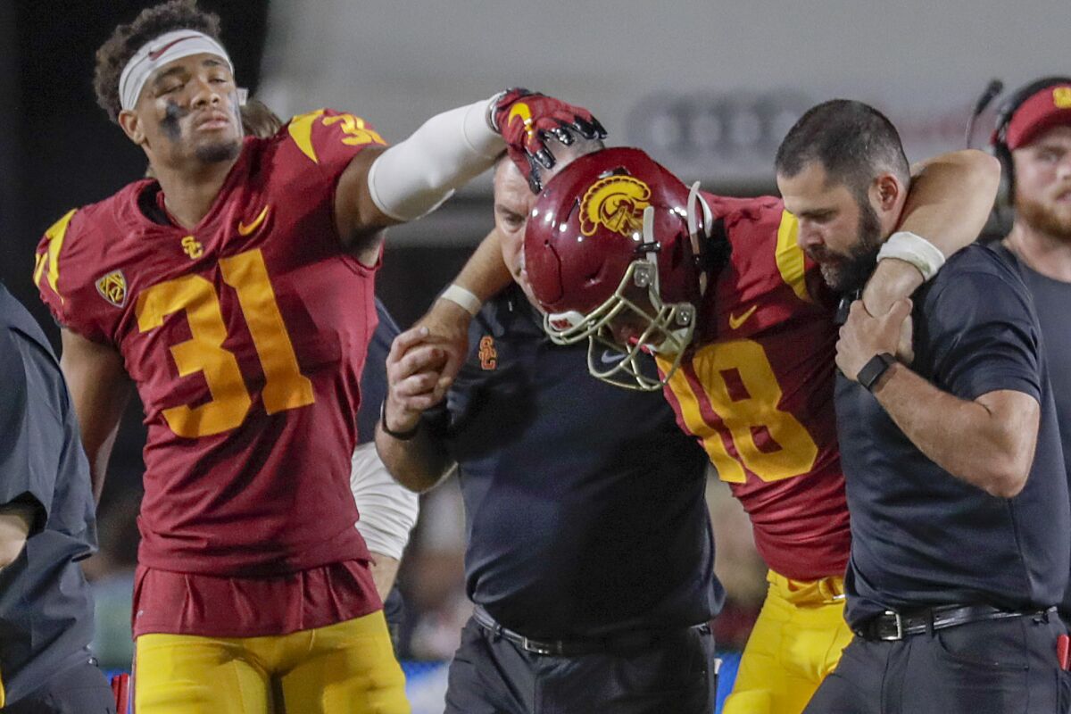 USC safety Richard Hagestad reaches out to console JT Daniels as he is helped off the field.