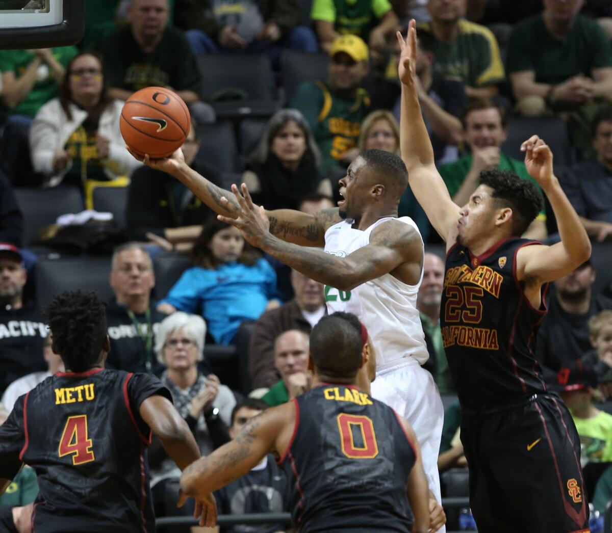 Oregon's Elgin Cook, top center, goes up for two points under pressure from USC's Chimezie Metu (4), Darion Clark (0) and Bennie Boatwright, right, during the second half of a game on Jan. 21.