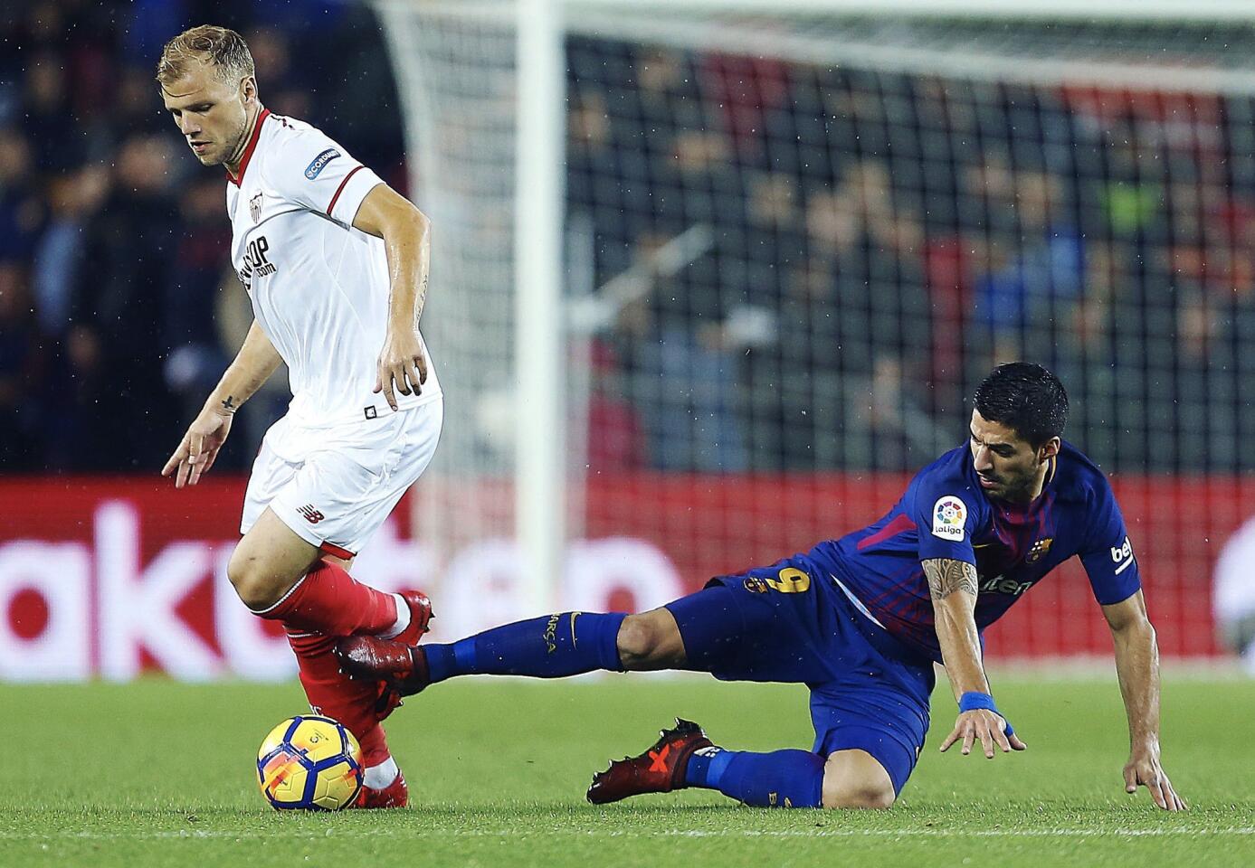 GRA069. BARCELONA, 04/11/2017.- El defensa danés del Sevilla Simon Kjaer (i) escapa de Luis Suárez, del FC Barcelona, durante el partido de Liga en Primera División disputado esta noche en el Camp Nou. EFE/Alejandro García ** Usable by HOY and SD Only **