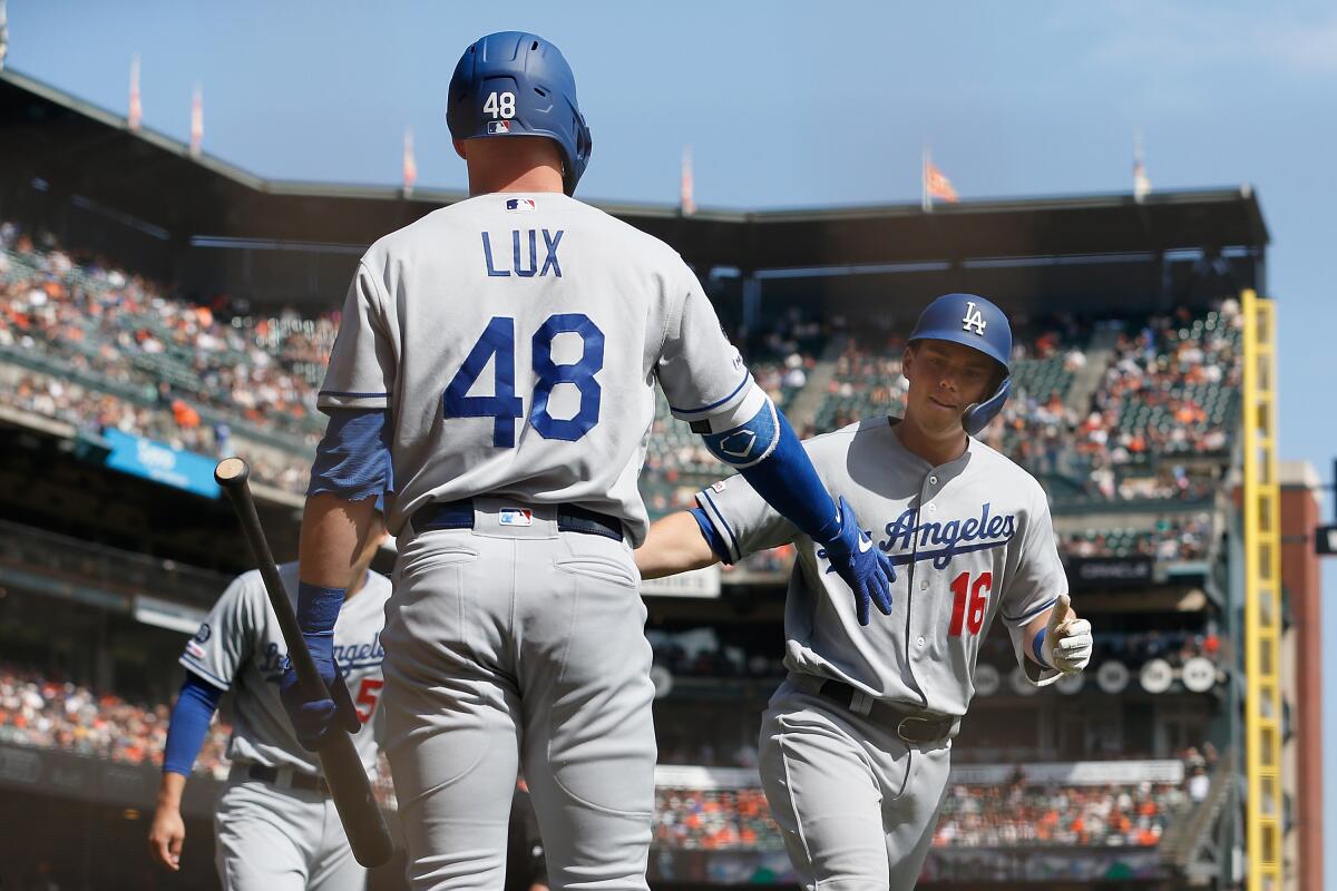 Dodgers catcher Will Smith, right, is congratulated by teammate Gavin Lux.