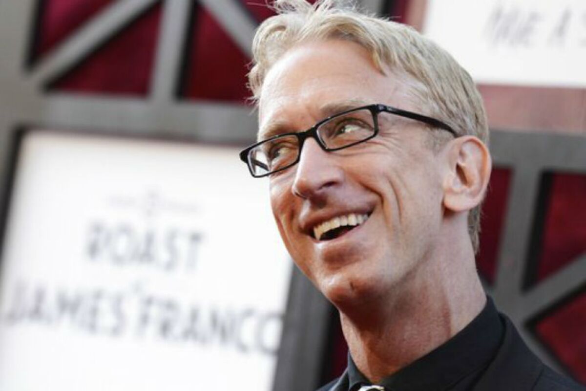 Andy Dick, in black shirt and jacket, smiles at something off-camera