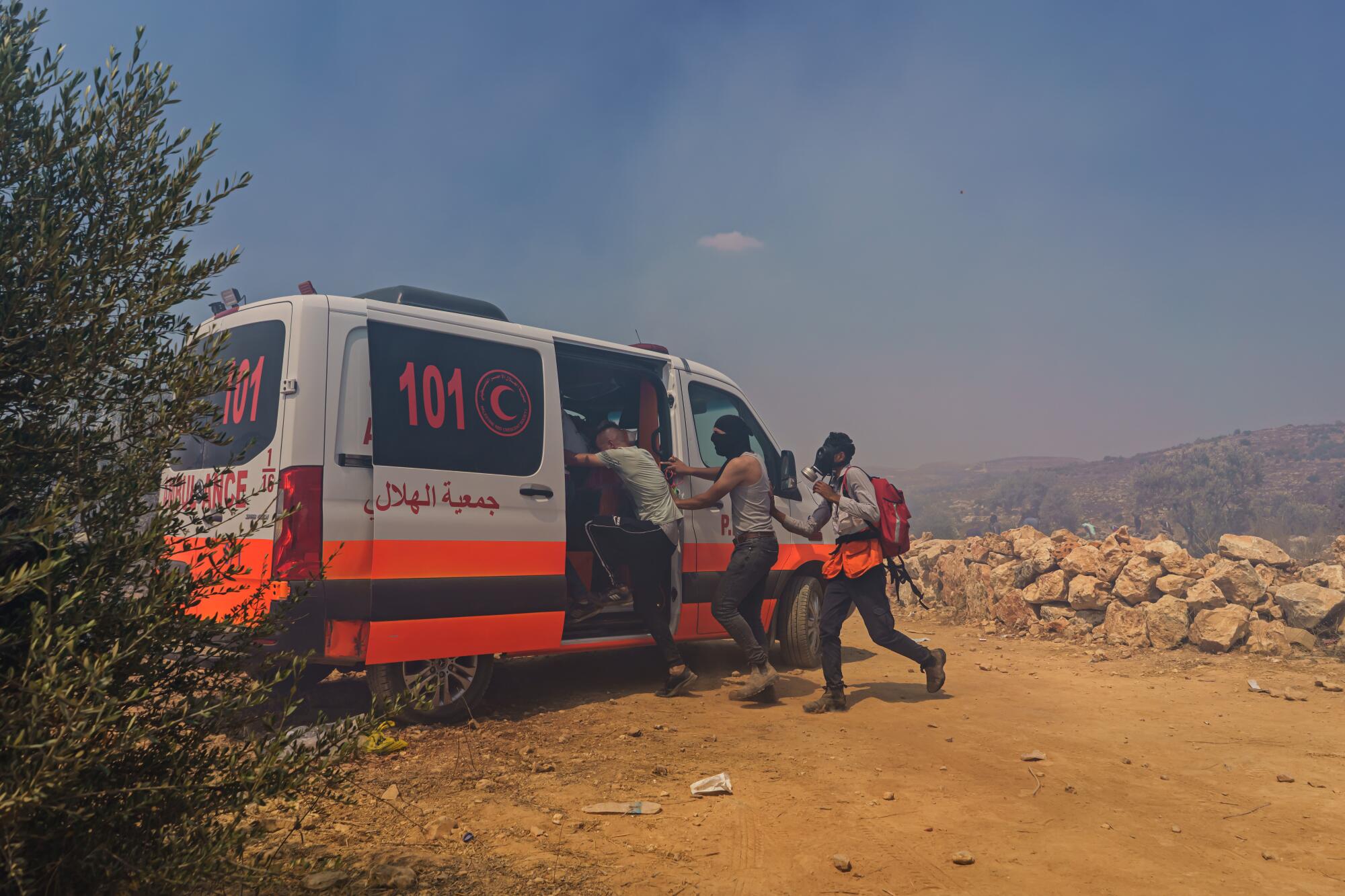 Palestinians seek shelter from tear gas in an ambulance