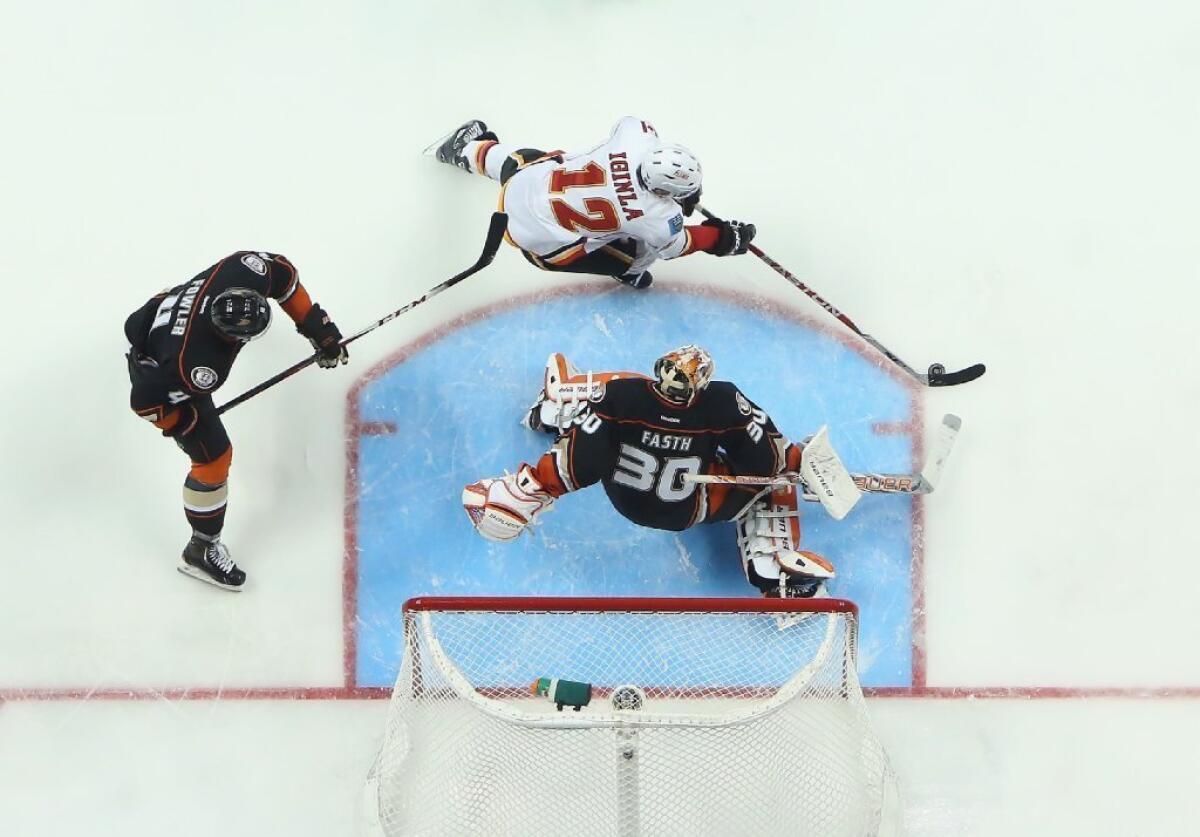 Jarome Iginla is pursued by Cam Fowler of the Ducks as goaltender Viktor Fasth defends his net in the Flames-Ducks game on March 8.