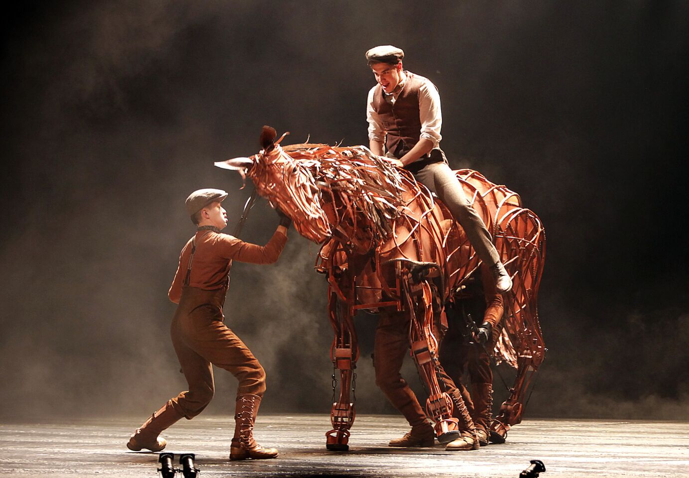 Andrew Veenstra (playing Albert Narracott) mounts the horse Joey for the first time in the Tony Award-winning play "War Horse" at the Ahmanson Theatre in July. Puppeteer Christopher Mai operates the head of the horse. Review: "War Horse" at Ahmanson Theatre is a marvel of stagecraft | Photos