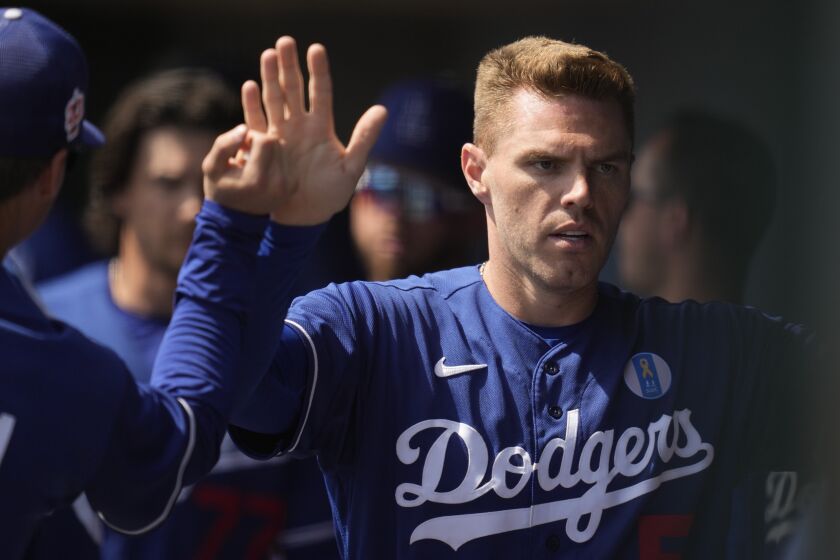 Los Angeles Dodgers designated hitter Freddie Freeman (5) celebrates in the dugout after scoring off of a single hit by Chris Taylor during the first inning of a spring training baseball game against the Chicago White Sox in Glendale, Ariz., Saturday, March 18, 2023. (AP Photo/Ashley Landis)