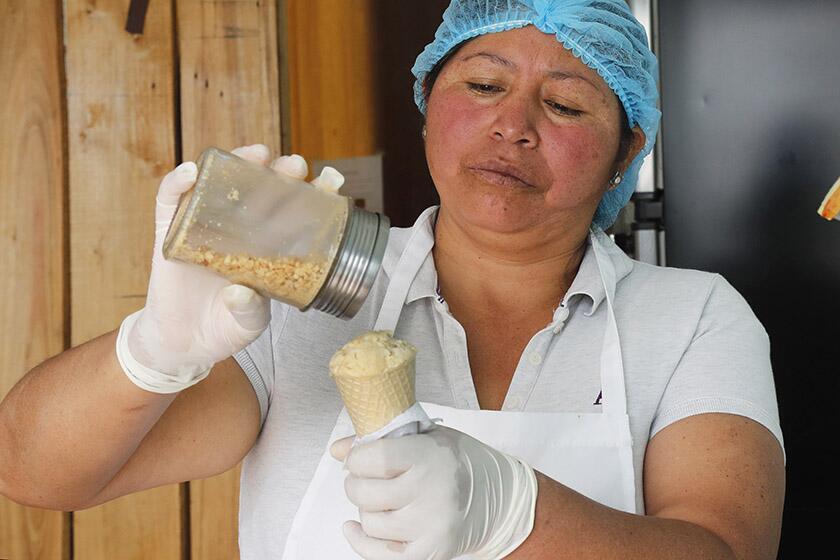 Maria del Carmen Pilapana puts the finishing touches on a guinea pig ice cream cone at her stall on the outskirts of Quito, Ecuador.