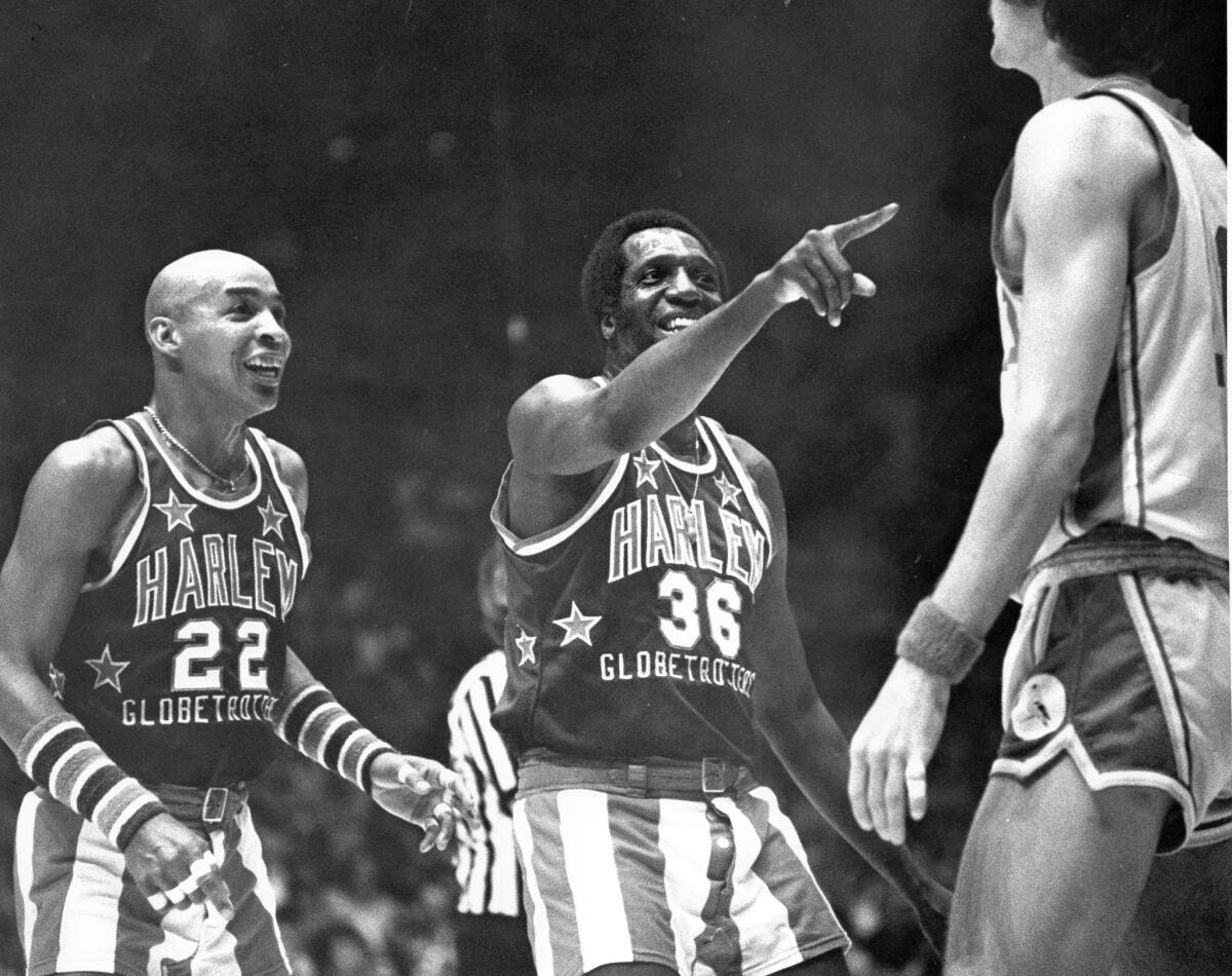 Harlem Globetrotters Curly Neal, left, and Meadowlark Lemon ham it in a 1977 game against a typically hapless opponent. Lemon, the "Clown Prince of Basketball" who spent 24 years with the barnstoming team, has died at the age of 83.