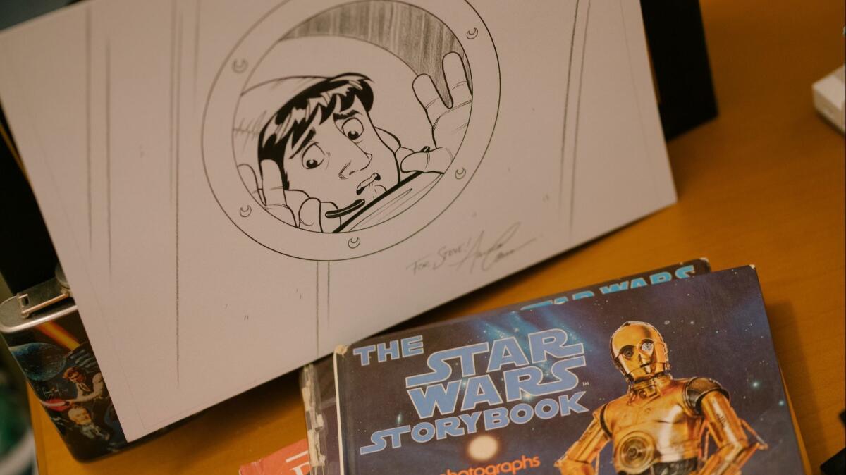 Original artwork and a Star Wars book sit on a shelf in "Big Bang Theory" showrunner Steve Hollands office on the Warner Bros. lot.