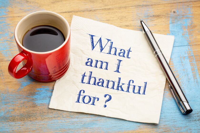 What am I thankful for? A question in handwriting on a napkin with a cup of espresso coffee