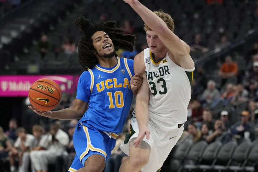 UCLA's Tyger Campbell (10) drives into Baylor's Caleb Lohner (33) during the first half.