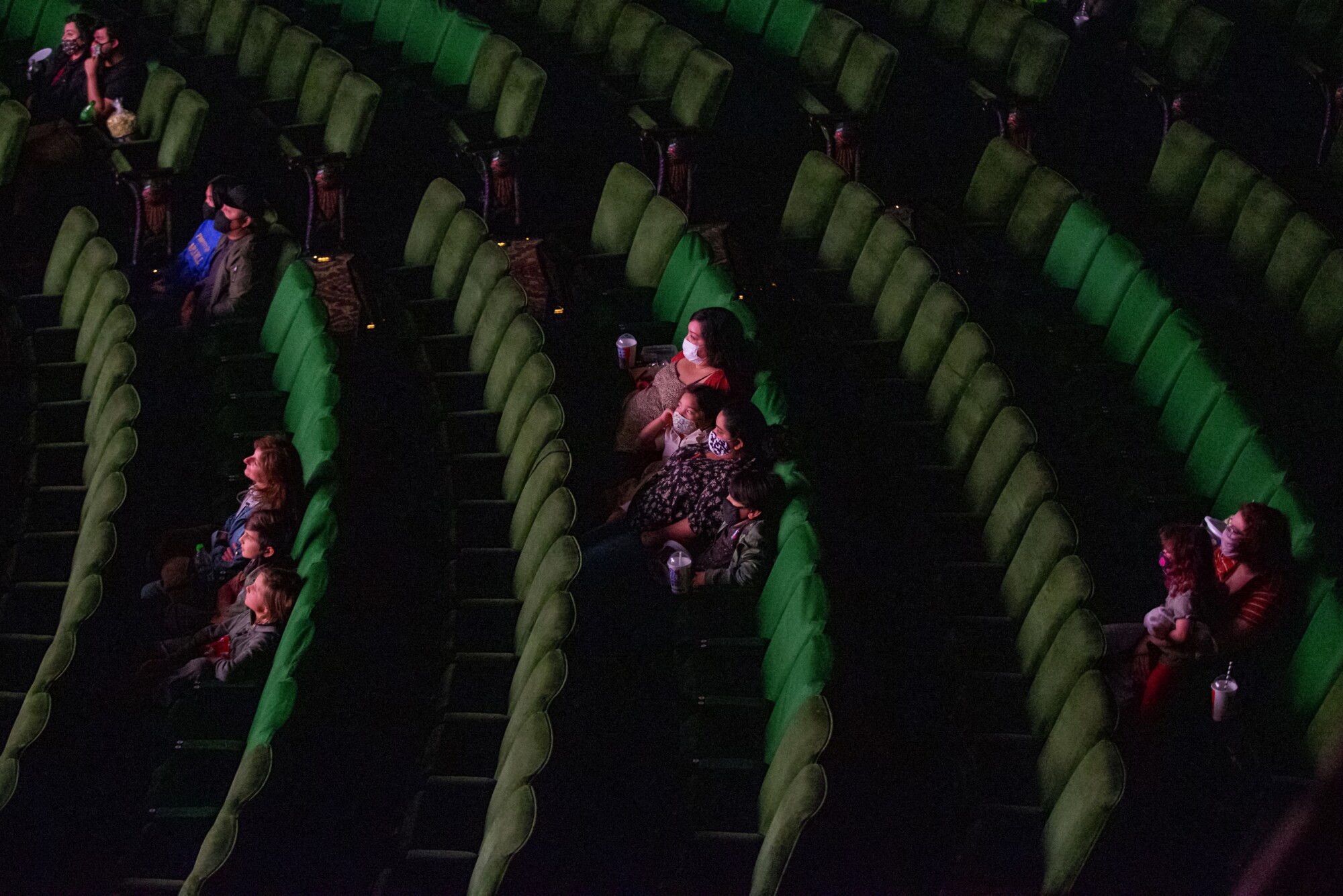 People sit spaced out in a movie theater.