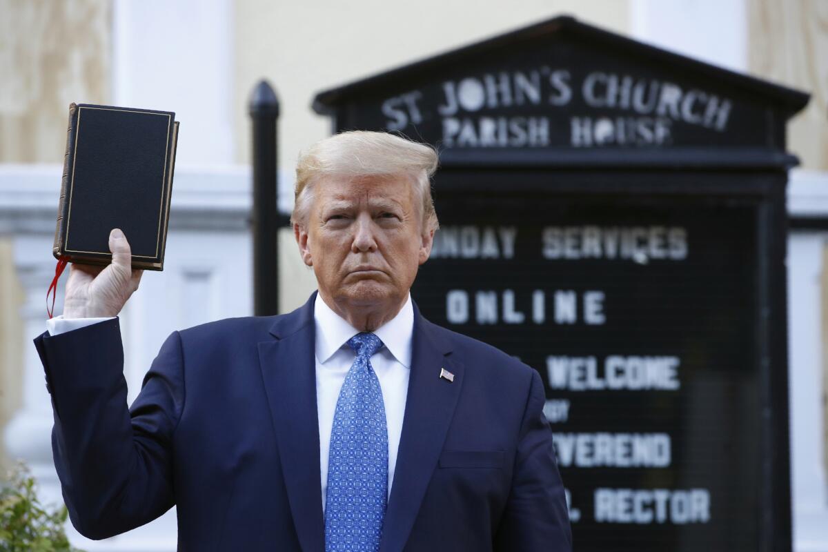 ARCHIVO - El presidente Donald Trump sostiene una Biblia frente 