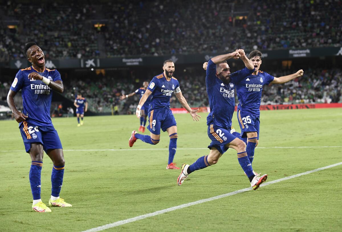 Real Madrid's Dani Carvajal, second right, celebrates with teammates after scoring his side's opening goal during the Spanish La Liga soccer match between Real Betis and Real Madrid at Benito Villamarin stadium in Seville, Spain, Saturday, Aug. 28, 2021. (AP Photo/Jose Breton)