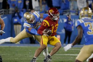 USC quarterback Caleb Williams avoids a sack by UCLA linebacker Lalatu Latu