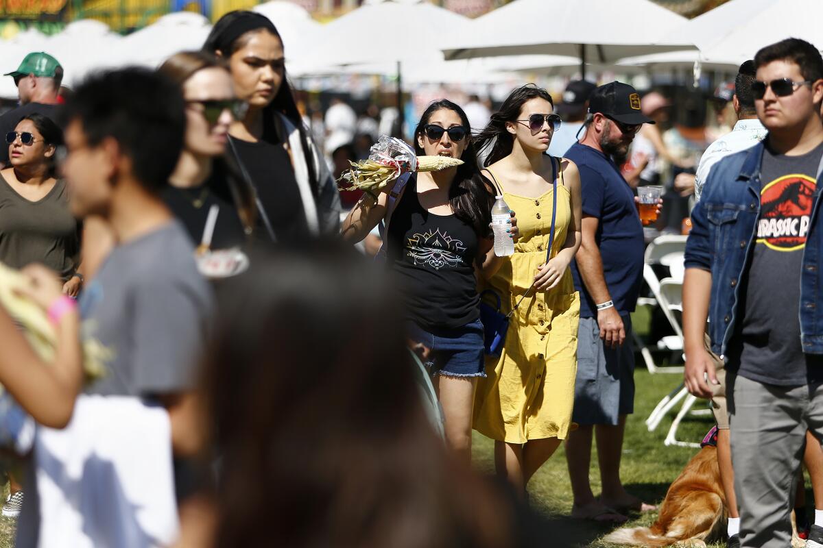 A woman bites into corn on the cob during Summerfest at Fountain Valley Sports Park on Saturday.