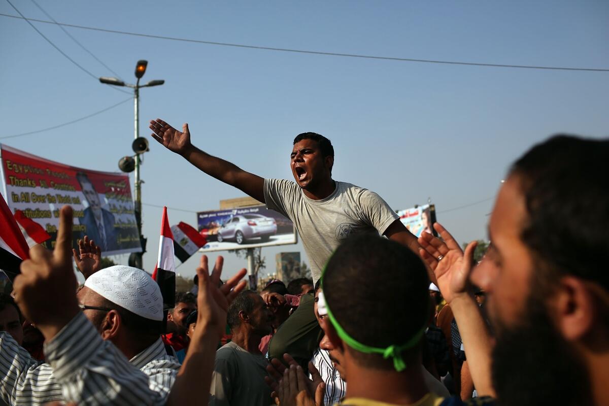 Supporters of ousted Egyptian President Mohamed Morsi rally in Cairo, Egypt, where more than 50 people were purported to have been killed by members of the Egyptian military and police. The country is in a state of political paralysis following the ousting of Morsi by the military.
