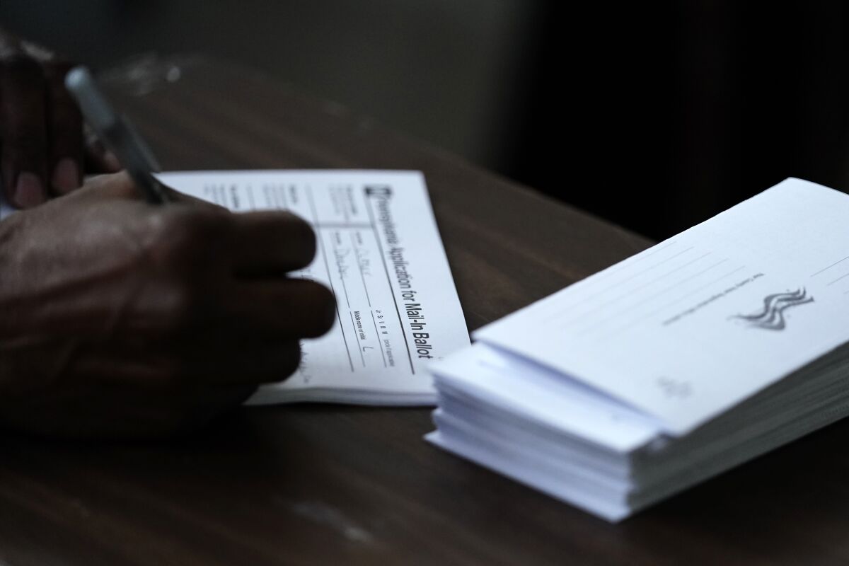 A person fills out an application for a mail-in ballot before voting.