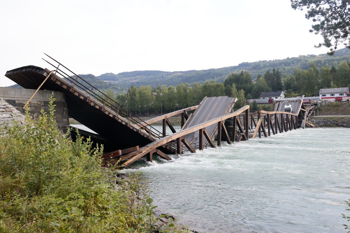 A view of a bridge that has collapsed over the River Laagen, in Gudbrandsdalen, Norway, Monday, Aug. 15, 2022. A wooden bridge over a river in southern Norway has collapsed with a car plunging into the water and a truck getting stuck on a collapsed section. Police said the drivers of both vehicles were rescued and doing well. (Geir Olsen/NTB Scanpix via AP)