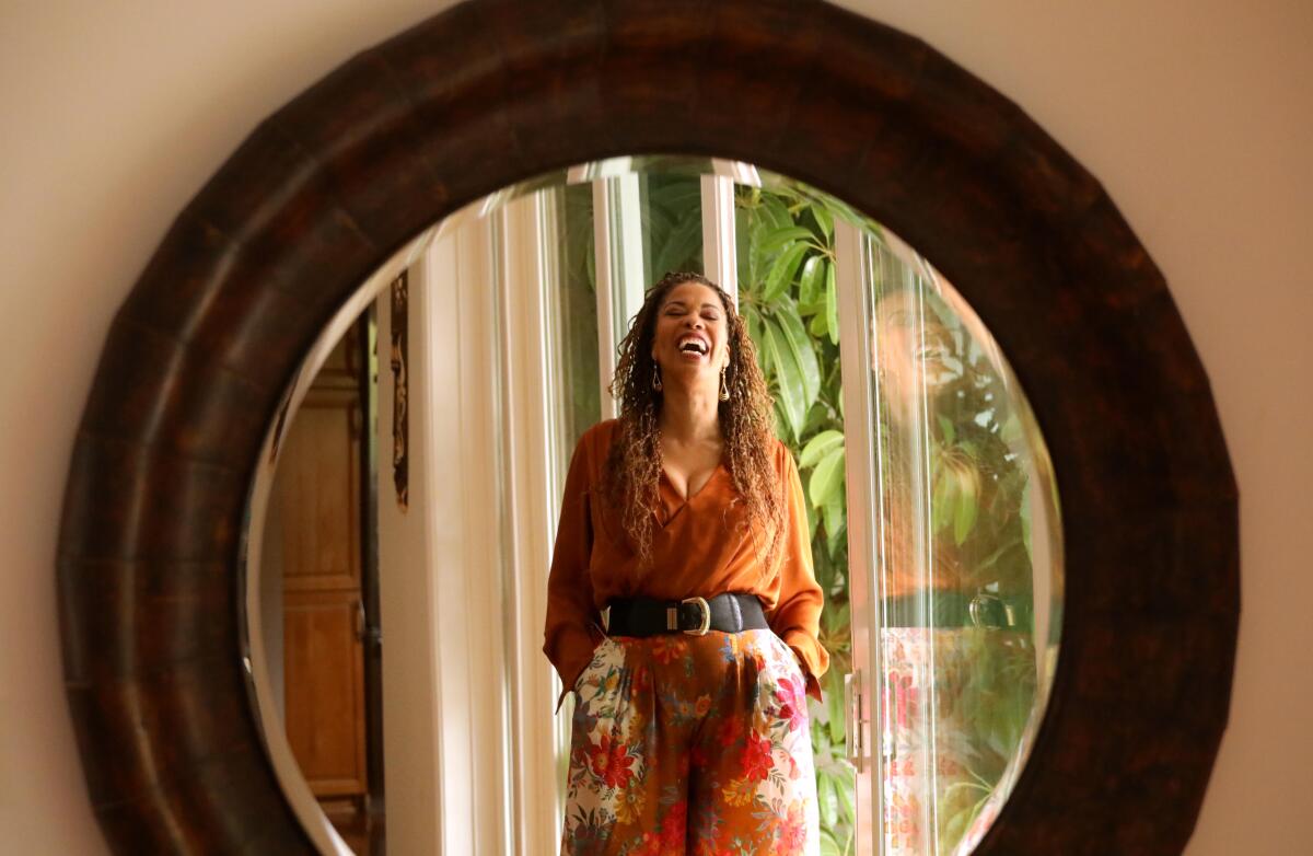 A laughing woman is reflected in a mirror.