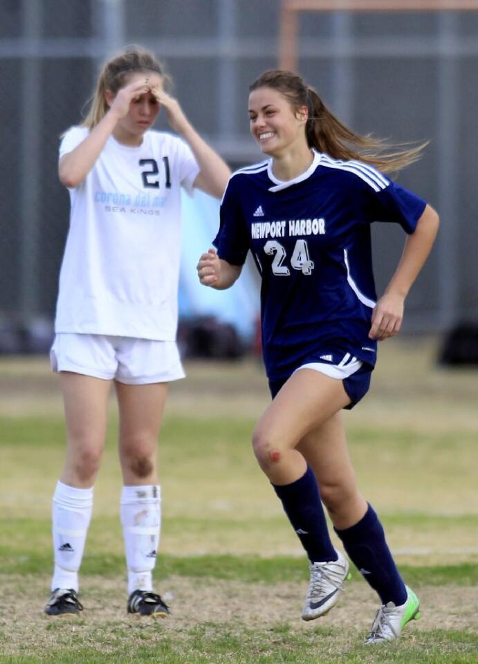 Newport Harbor High's Sianna Siemonsma (24) is all smiles as she jogs by Corona del Mar's Allie Doherty (21) after scoring a goal during the second half in the Battle of the Bay match on Tuesday.