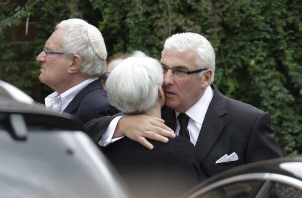 Father Mitch Winehouse consoles a mourner.