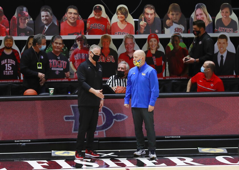 SDSU coach Brian Dutcher (left) and UCLA coach Mick Cronin talk before their teams played at Viejas Arena last year.