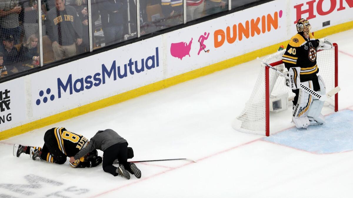 Boston Bruins' Matt Grzelcyk is tended to by the trainer after being hit into the boards by St. Louis Blues' Oskar Sundqvist (not pictured) during the first period in Game 2 of the Stanley Cup Final at TD Garden on Wednesday in Boston.