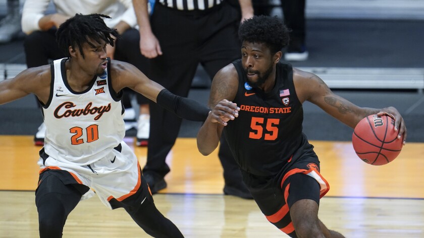 Oregon State guard Tariq Silver drives on Oklahoma State guard Keylan Boone in a men's college basketball game.