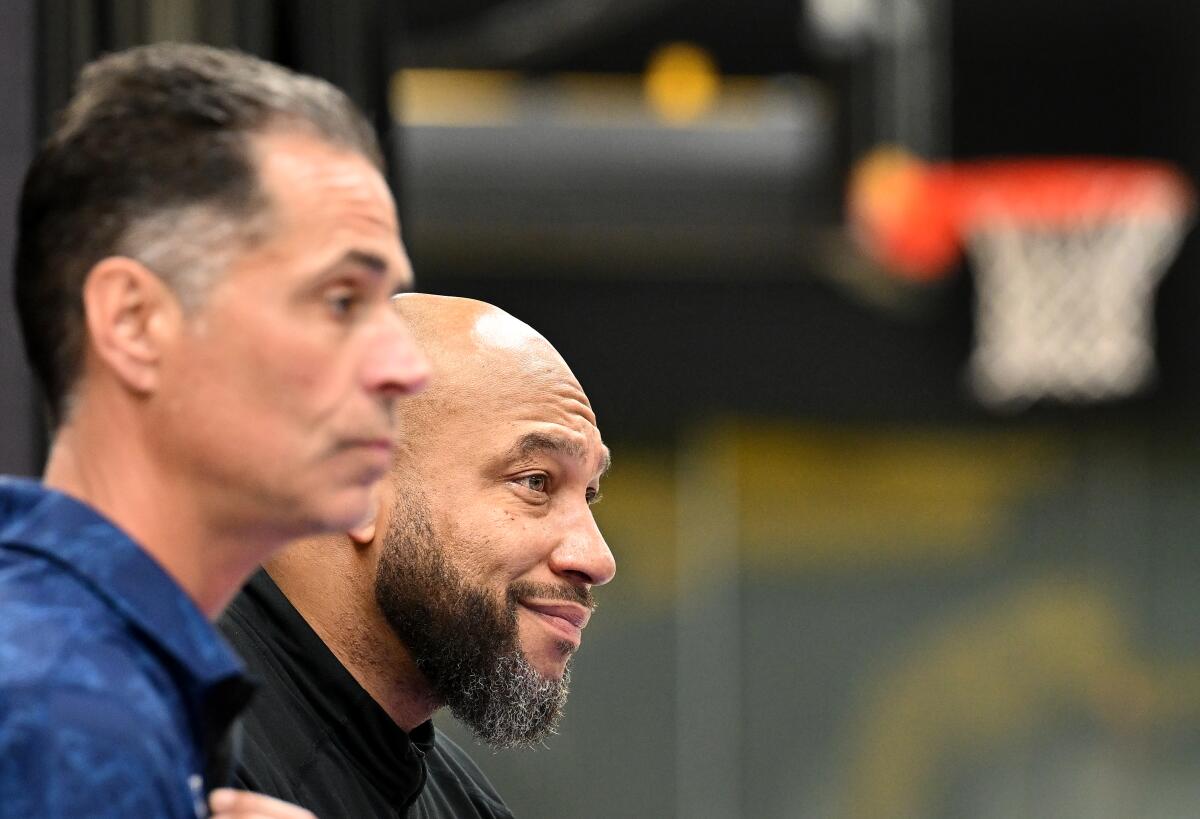 Lakers general manager Rob Pelinka (left) and coach Marvin Hamm interviewed by the media.