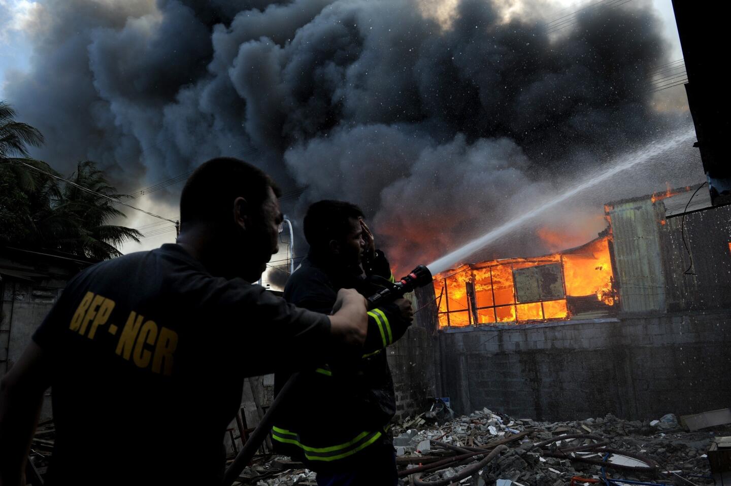 Firefighters extinguish a fire that engulfed a residential area in Manila. Almost 400 houses were destroyed, leaving 600 families homeless, according to local media reports.