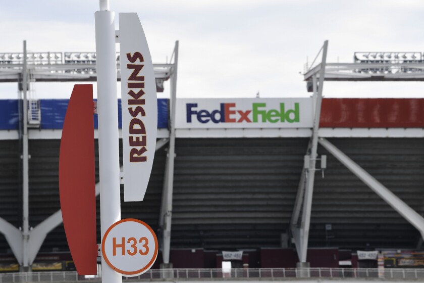 Signs for the Washington Redskins are displayed outside FedEx Field in Landover, Md.