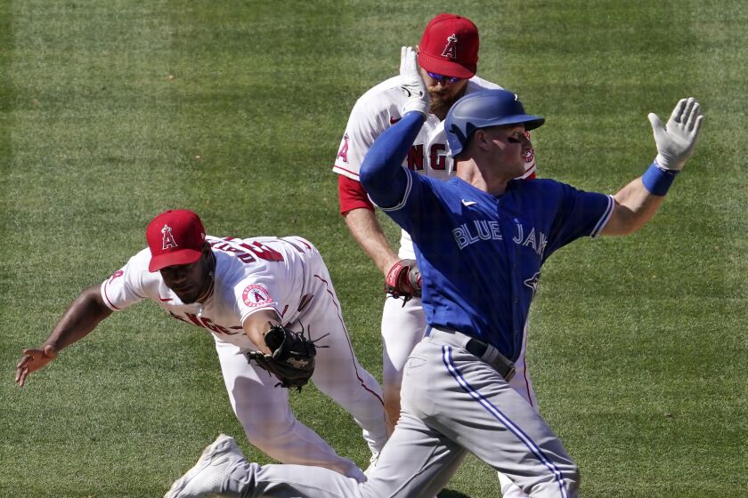 Toronto Blue Jays' Matt Chapman, right, avoids a tag by Los Angeles Angels relief pitcher Oliver Ortega.
