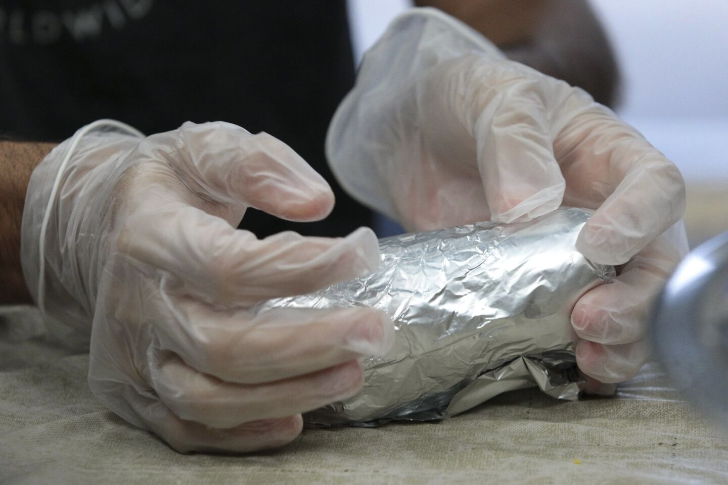 A Burrito Boyz volunteer wraps an egg burrito in foil.