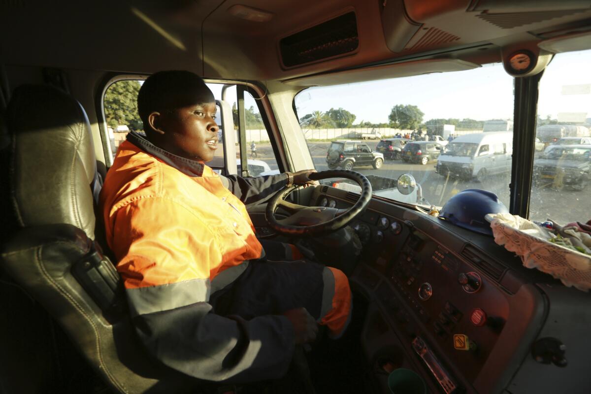 Molly Manatse a female truck driver is seen on the road in Harare, in this Saturday, March, 6, 2021 photo. There are very few female truck drivers in Zimbabwe, but Manatse doesn't like to be singled out for her gender. From driving trucks and fixing cars to encouraging girls living with disability to find their places in society, women in Zimbabwe are refusing to be defined by their gender or circumstances, even as the pandemic hits them hardest and imposes extra burdens.(AP Photo/Tsvangirayi Mukwazhi)