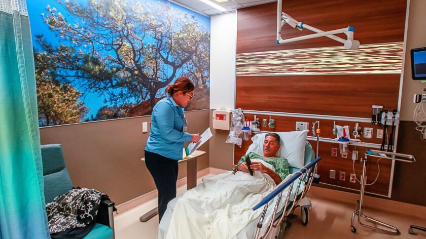 Patient access lead Alexis Hernandez collects information from patient Frank Staffiero of San Diego in a patient room at the Gary and Mary West Senior Care Unit inside UCSD Jacobs Medical Center Wednesday.