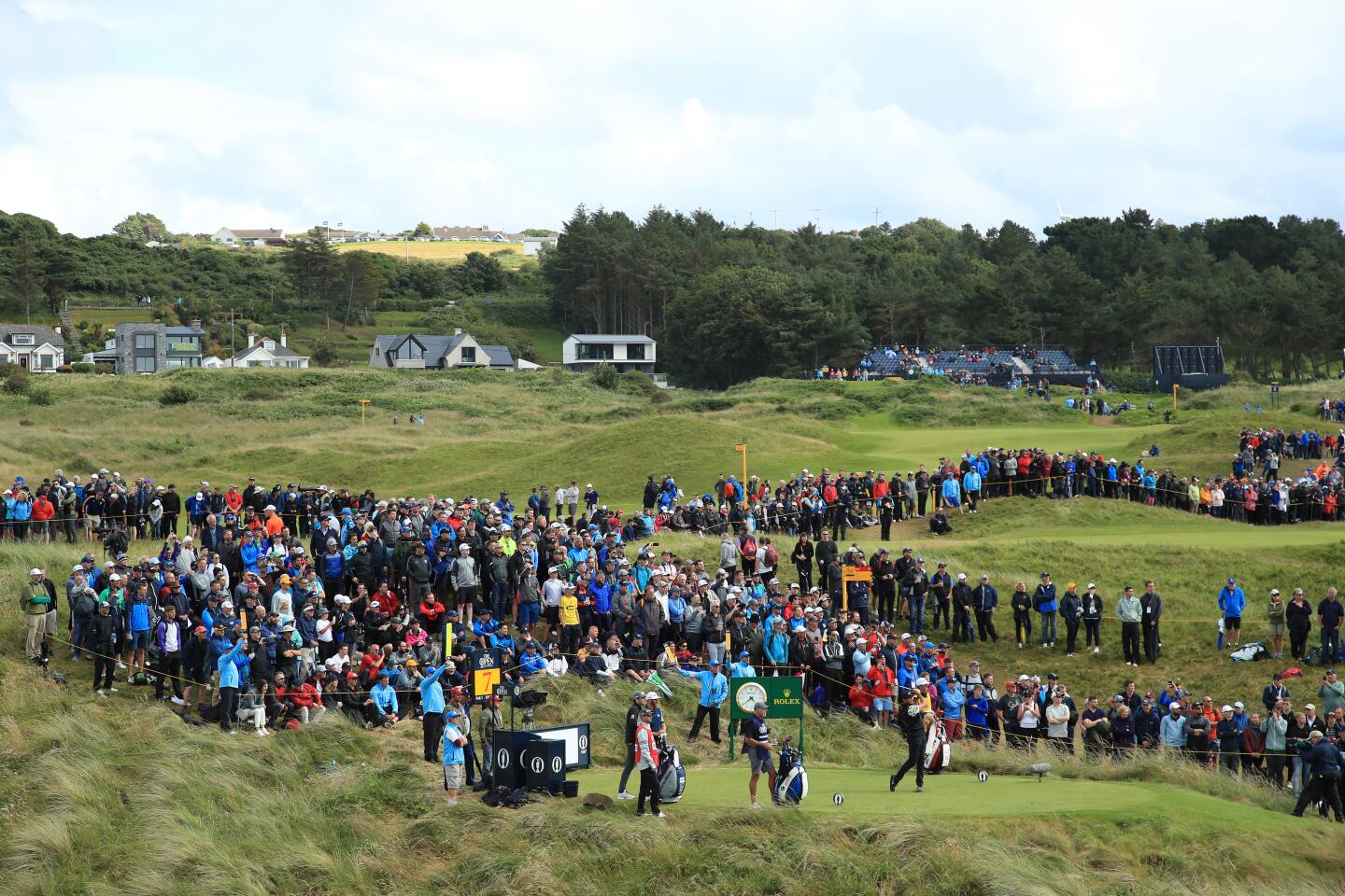 Jason Day of Australia tees off on the seventh hole, foreground, during the first round of the 148th Open Championship at Royal Portrush Golf Club in Northern Ireland.