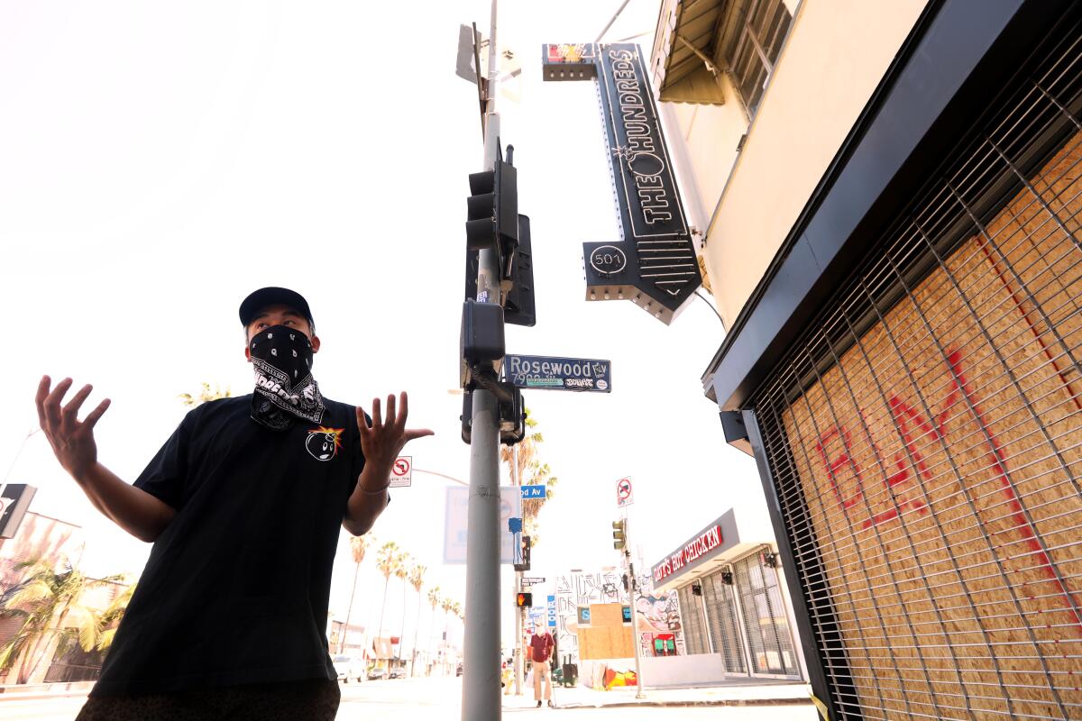 Bobby Kim, co-owner of the Hundreds store, stands in front of the boarded-up establishment on June 3, 2020.