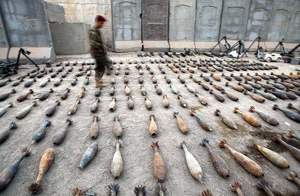 An Iraqi officer inspects a cache of weapons that had been found in an industrial area of Baghdad's Sadr City.