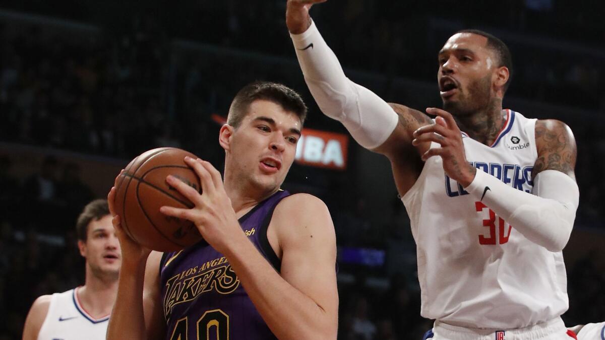 Lakers center Ivica Zubac works for position under the basket against Clippers forward Mike Scott during the second quarter on Dec. 28, 2018, at Staples Center.