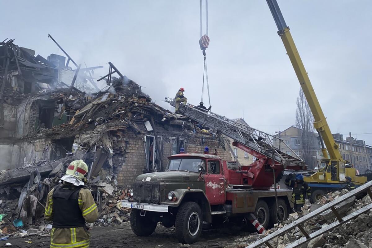 First responders at scene of building damaged by shelling in Ukraine