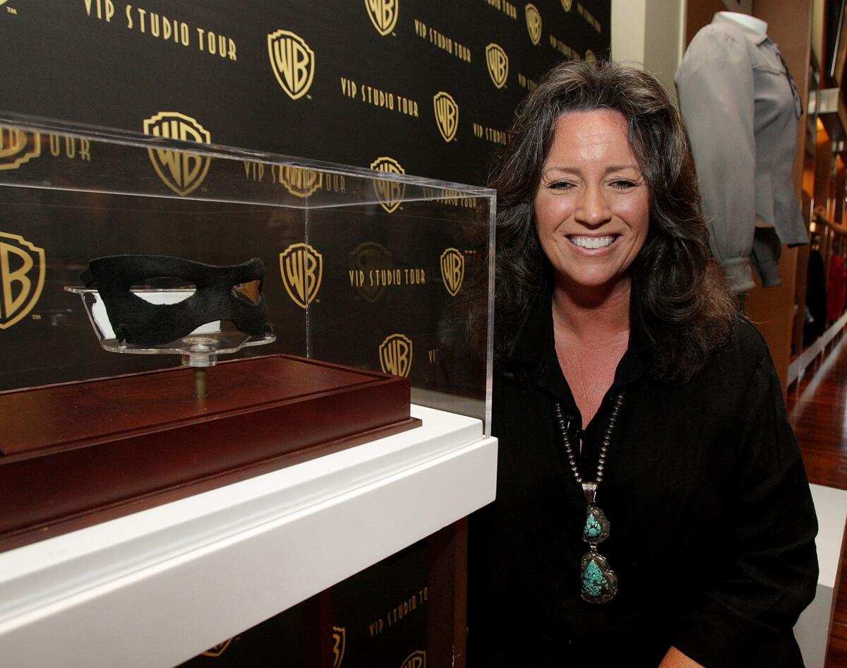 Dawn Moore, the daughter of Clayton Moore, the actor who played the Lone Ranger, kneels next to the actual hero's mask at the Meet the Family Speaker Series event at Warner Brothers in Burbank on Wednesday, September 10, 2014.