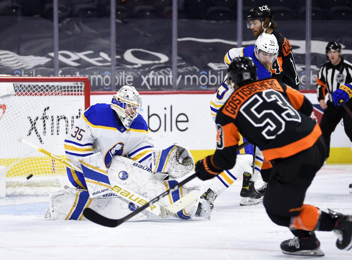 Buffalo Sabres' goaltender Linus Ullmark, left, is unable to make a save on a goal by Philadelphia Flyers' Shayne Gostisbehere (53) during the third period of an NHL hockey game, Sunday, April 11, 2021, in Philadelphia. (AP Photo/Derik Hamilton)