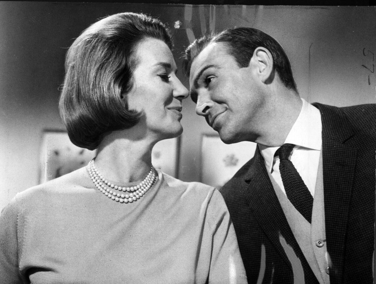 Connery's Bond pauses to flirt with Miss Moneypenny, played by Lois Maxwell, in a scene in "Goldfinger."