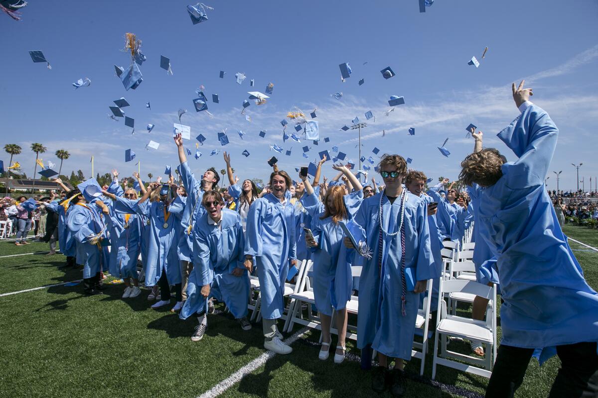 Corona del Mar High School graduates toss their caps.